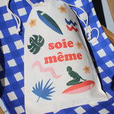 Drawstring bag with colorful graphics and text on a blue and white checkered background