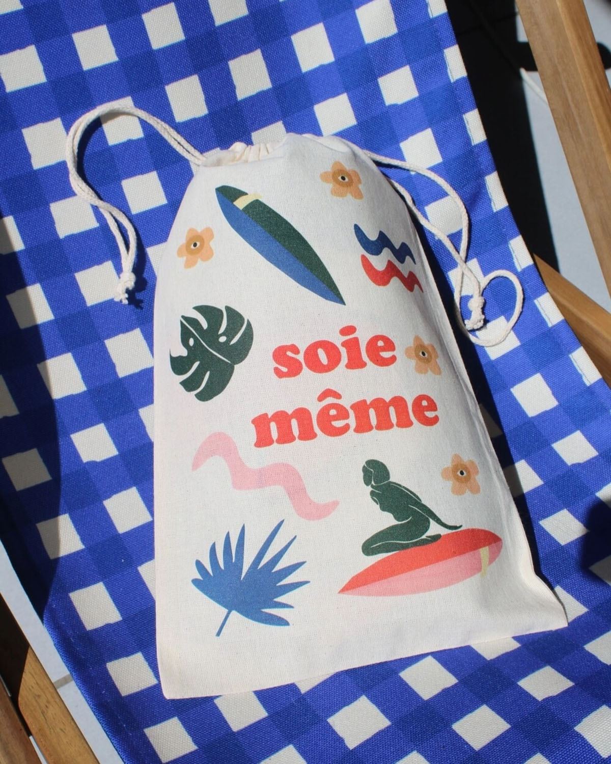 Drawstring bag with colorful graphics and text on a blue checkered background