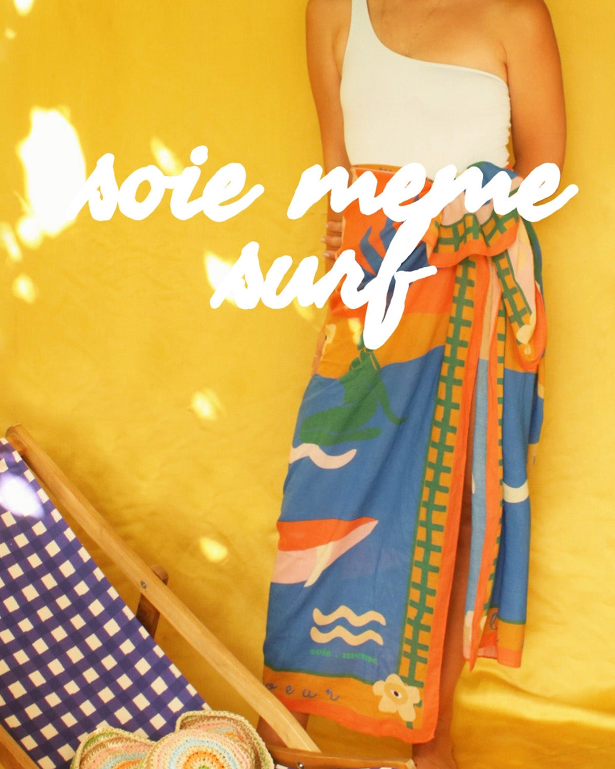 Person holding a colorful towel with 'série mème surf' text on a yellow background