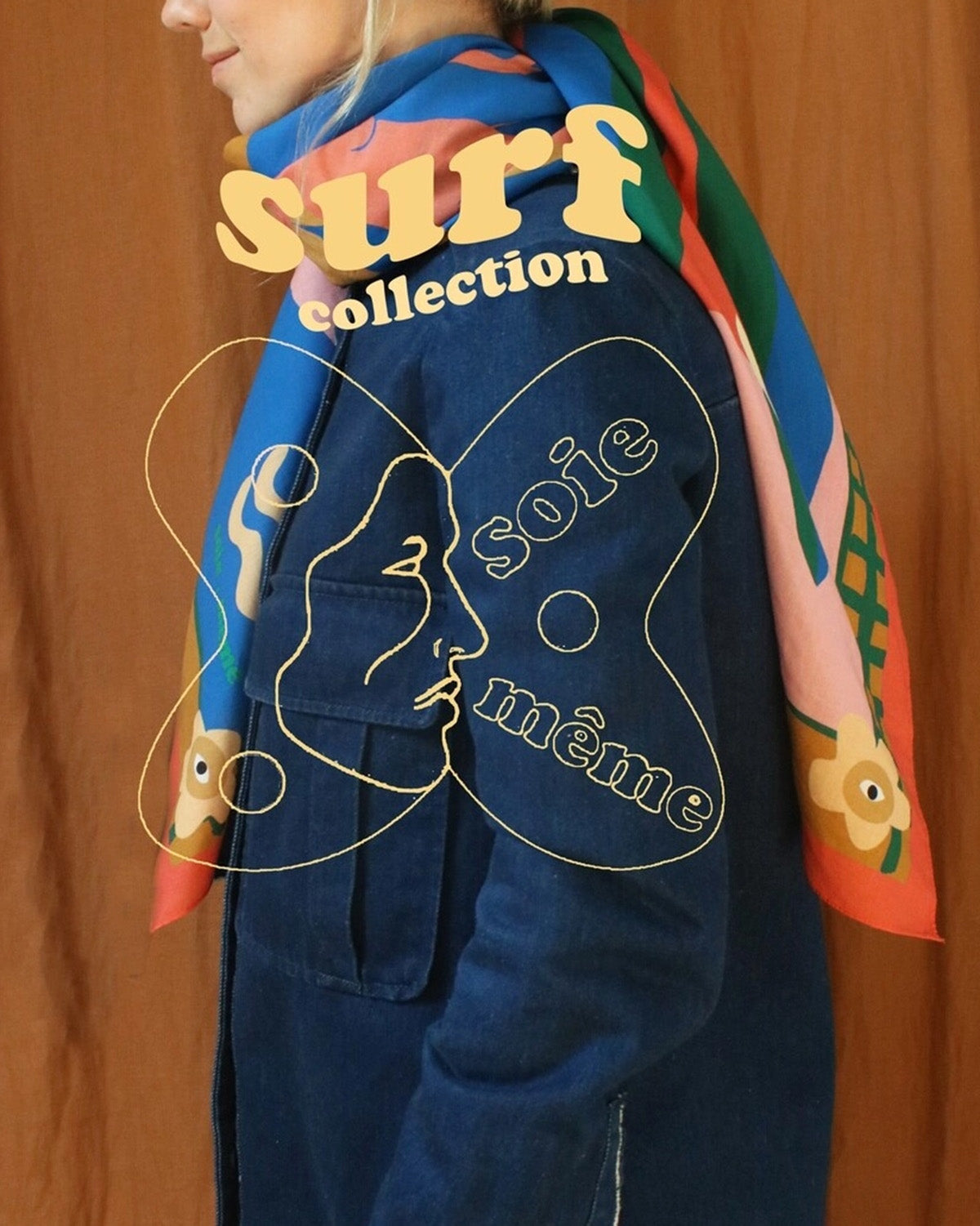 Person wearing a colorful jacket with 'surf collection' text and artistic design on an orange background