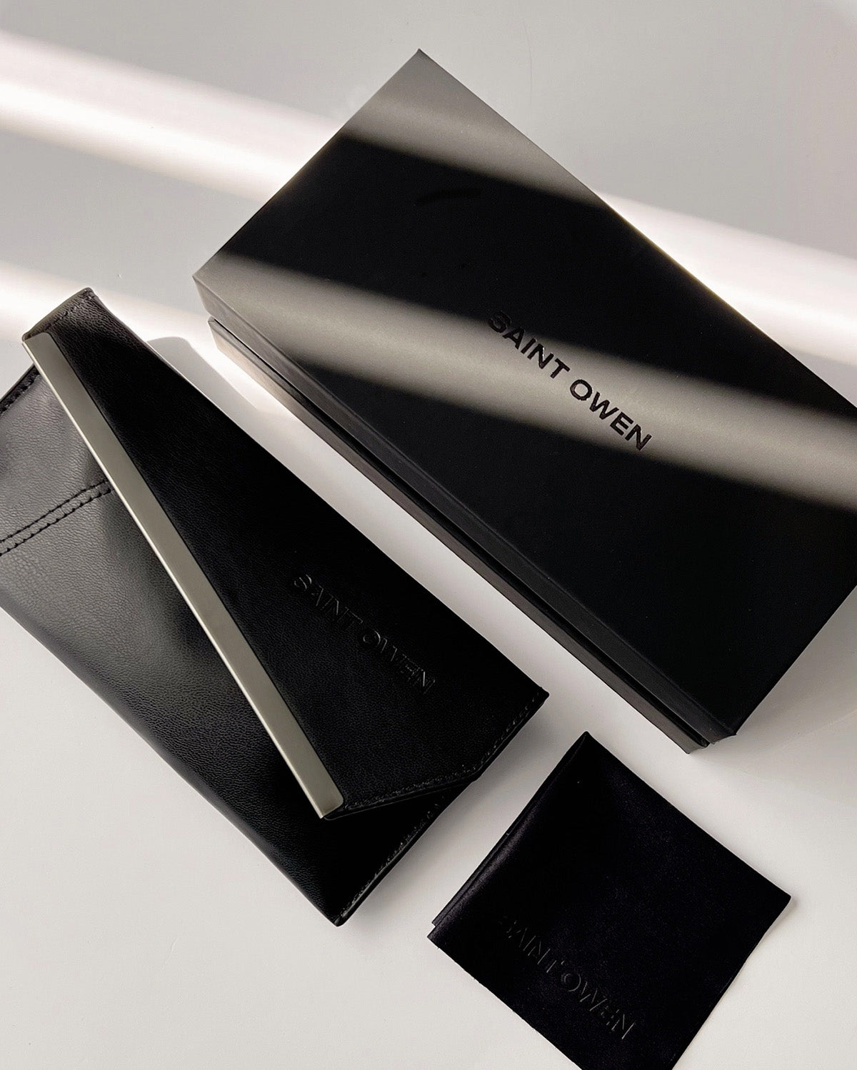 Black Saint Owen wallet and cardholder set on a light gray background