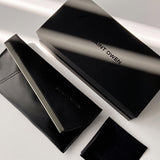 Black Saint Owen wallet and cardholder set on a light gray background