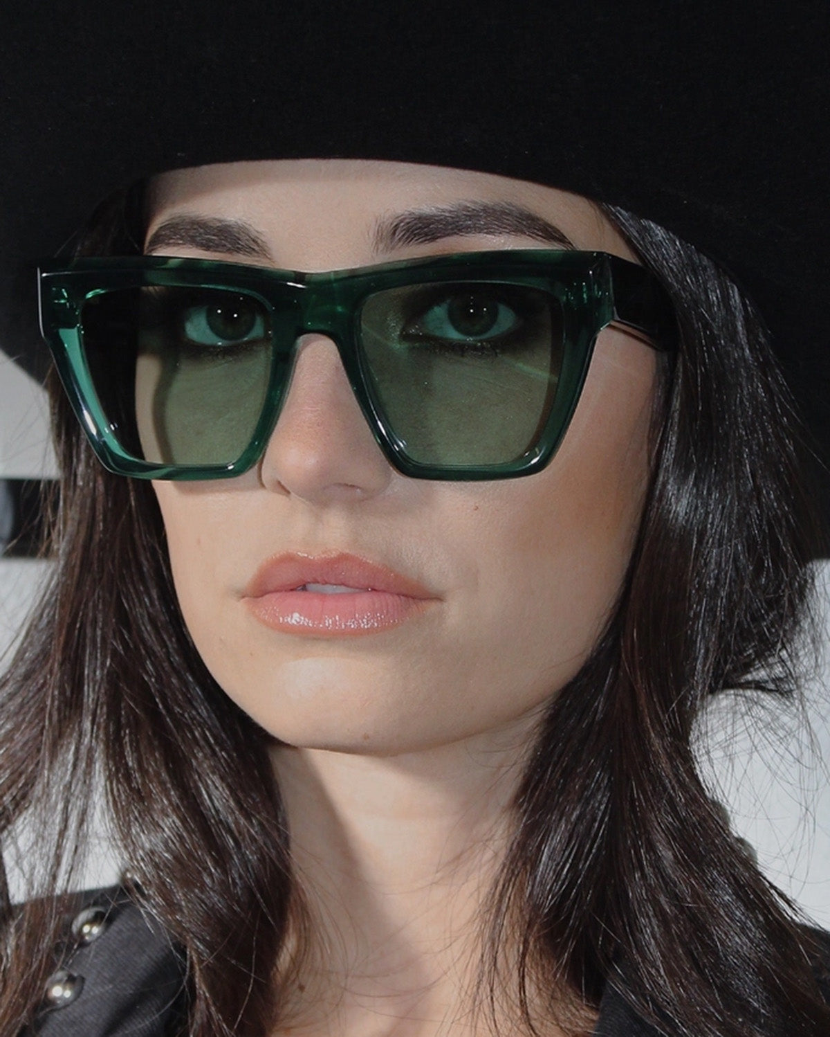 Person wearing green sunglasses with a blurred background