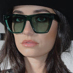 Person wearing green sunglasses with a blurred background