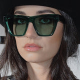 Person wearing green sunglasses with a blurred background