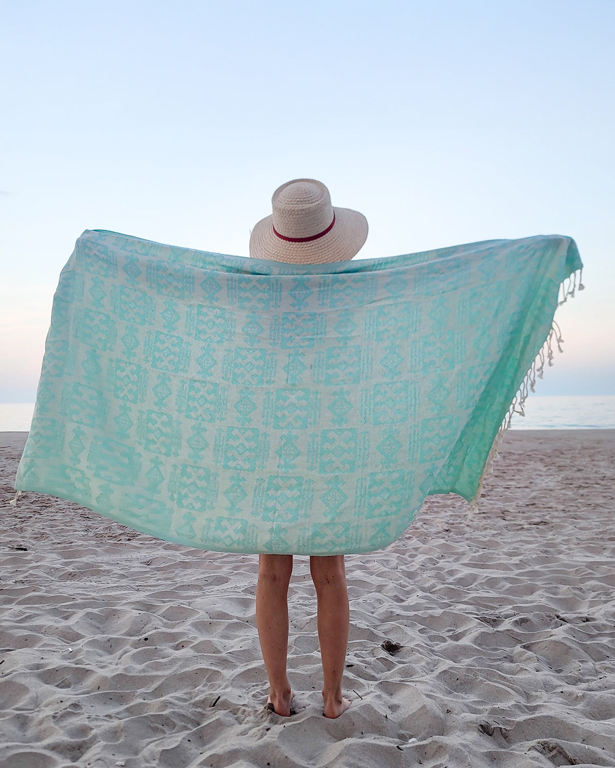 Girl holding turquoise geometric Turkish towel