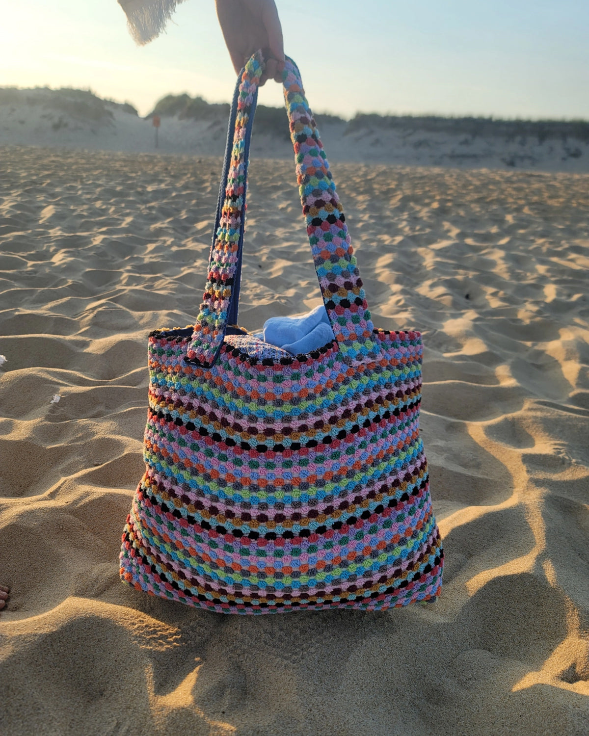 Colorful woven bag on a sandy beach